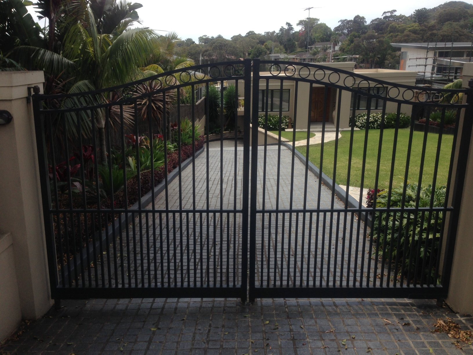 Automatic swinging gates Creators Range arch top with cirlces and mid height doggy bars Sydney